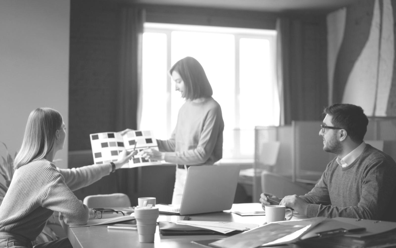 Students collaborating on financial modeling project with laptops and documents